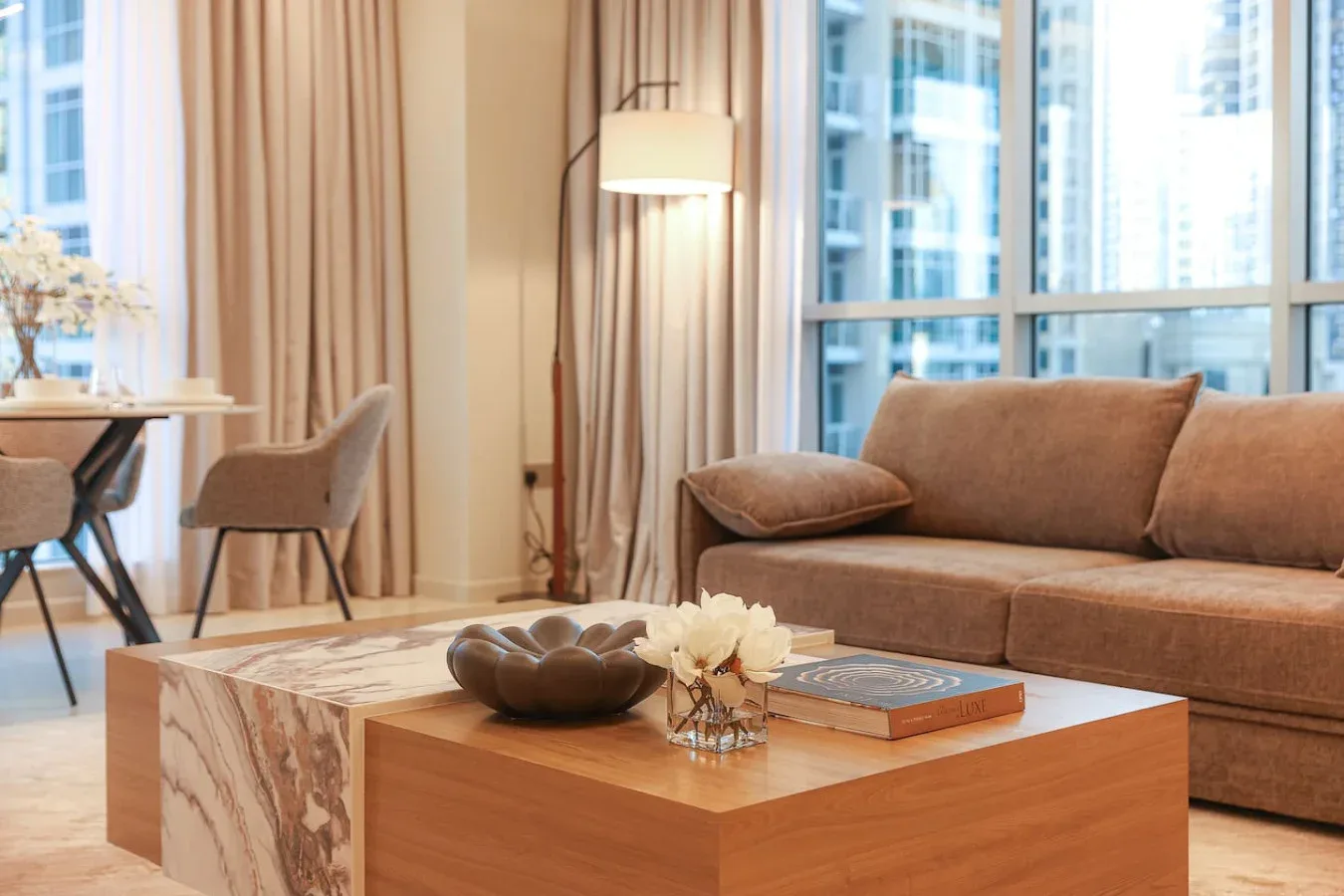 Una sala luminosa con asientos junto a grandes ventanas y una mesa de centro.
