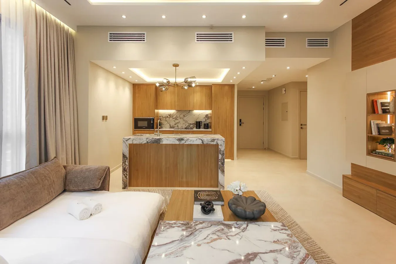 Una luminosa sala de estar comunica con una cocina compacta, con asientos y una barra.