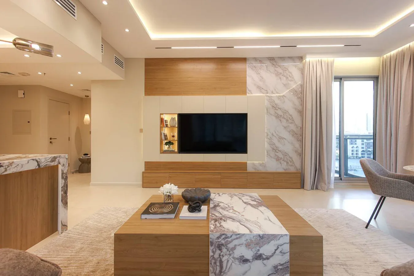Una sala de estar moderna con un televisor en la pared y una mesa de centro baja.