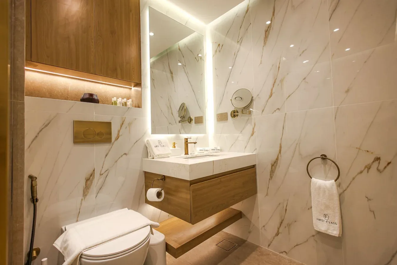 Un baño moderno con un lavabo suspendido y un espejo iluminado.
