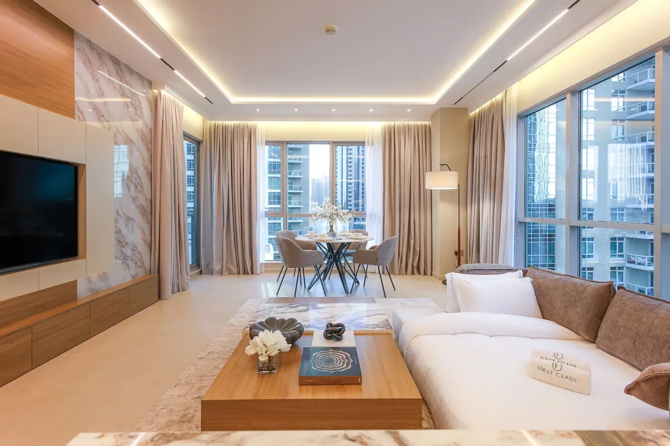 Una sala luminosa con asientos, una mesa de centro y grandes ventanas.