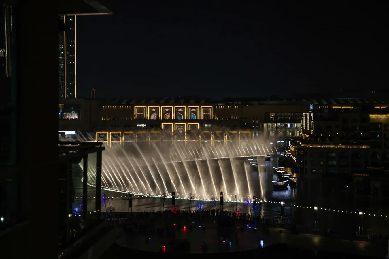 Un espectáculo nocturno de fuentes urbanas lanza chorros de agua iluminados al aire.