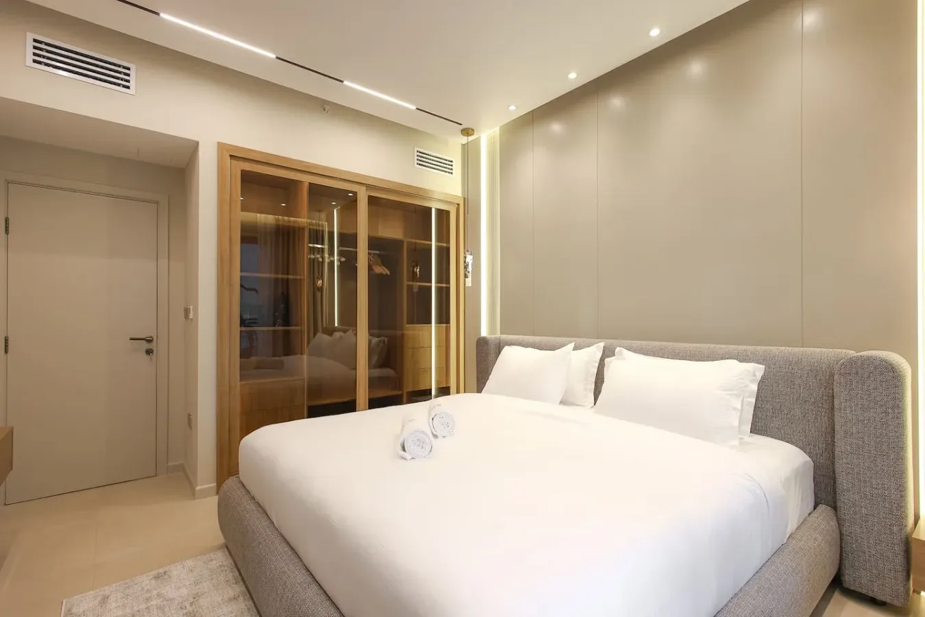 Un dormitorio con una cama grande y un armario con puertas de vidrio.