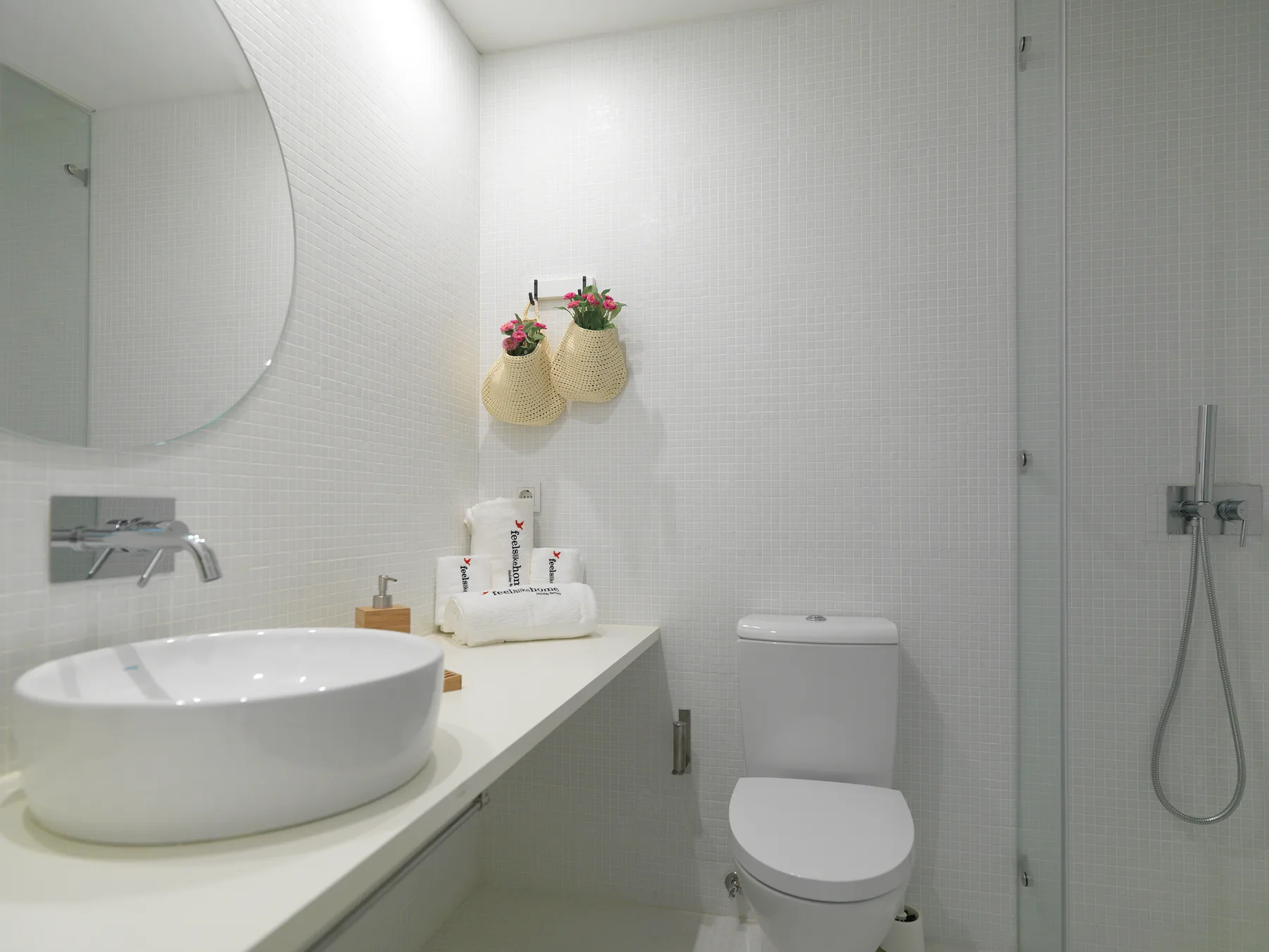 A bright bathroom with a vessel sink, toilet, and glass shower.