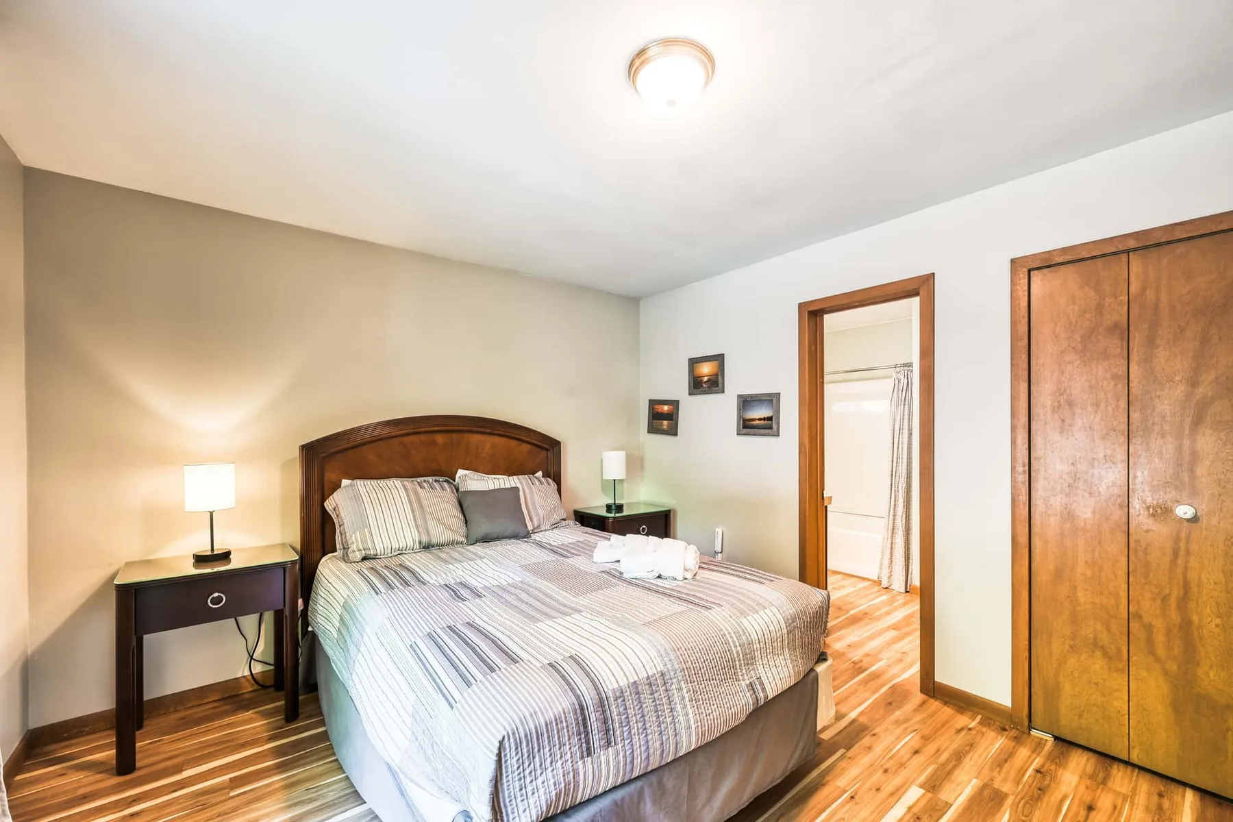 Un dormitorio con una cama doble, mesitas de noche y suelo de madera.