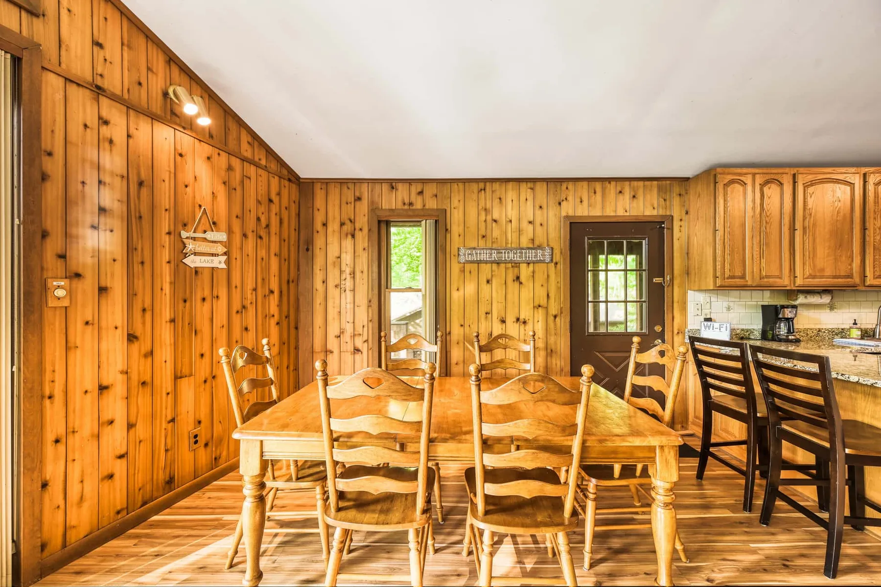 Comedor revestido de madera con una mesa larga y sillas.