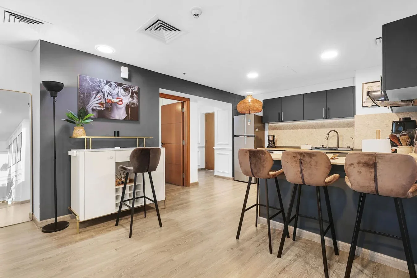 Una cocina moderna y comedor con una barra y asientos altos.