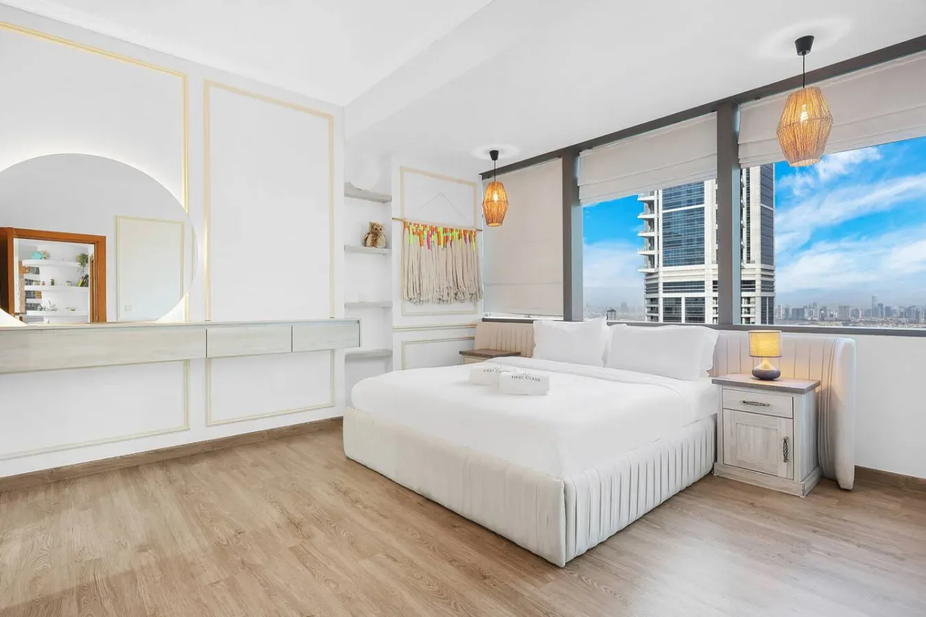 Un dormitorio luminoso con una cama grande junto a amplias ventanas.