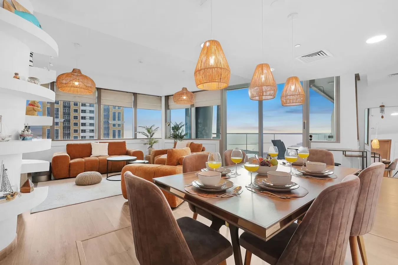 Un espacio abierto de sala y comedor con la mesa puesta y asientos.