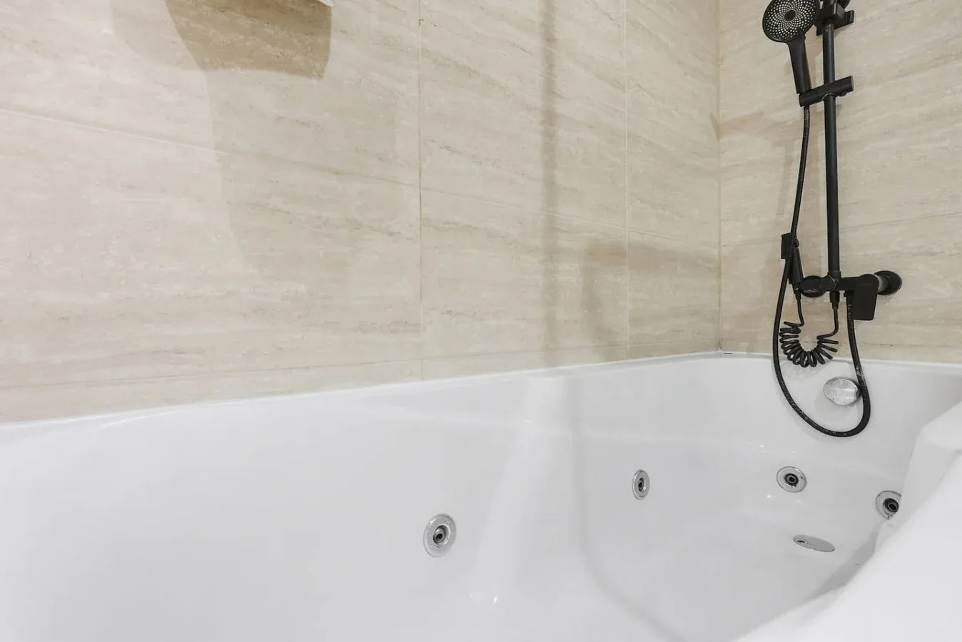 Un baño con una bañera de hidromasaje blanca y una ducha de pared.