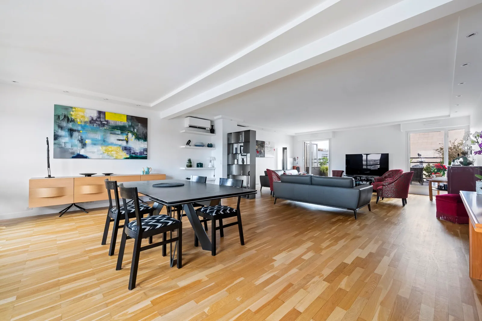 An open-plan living and dining area with a dark dining table and seating.