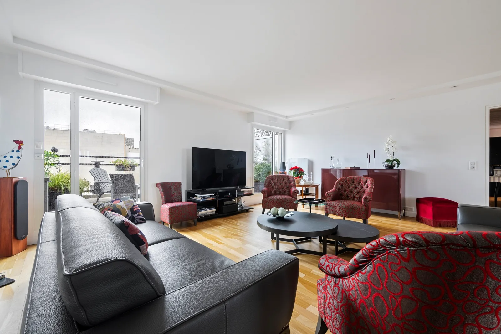 A bright living room with seating arranged around a television and coffee table.
