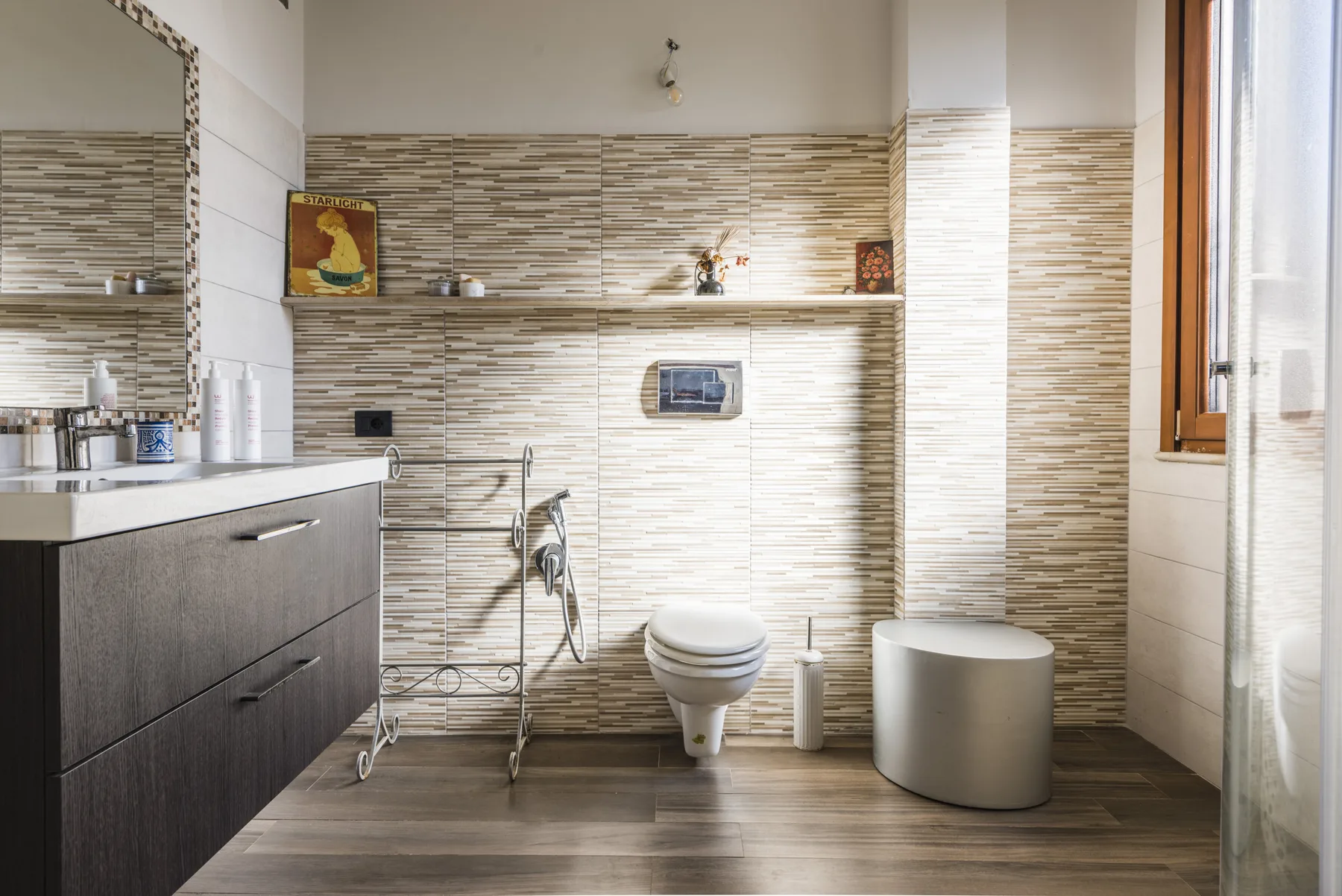 Un baño luminoso con lavabo, inodoro y zona de ducha.