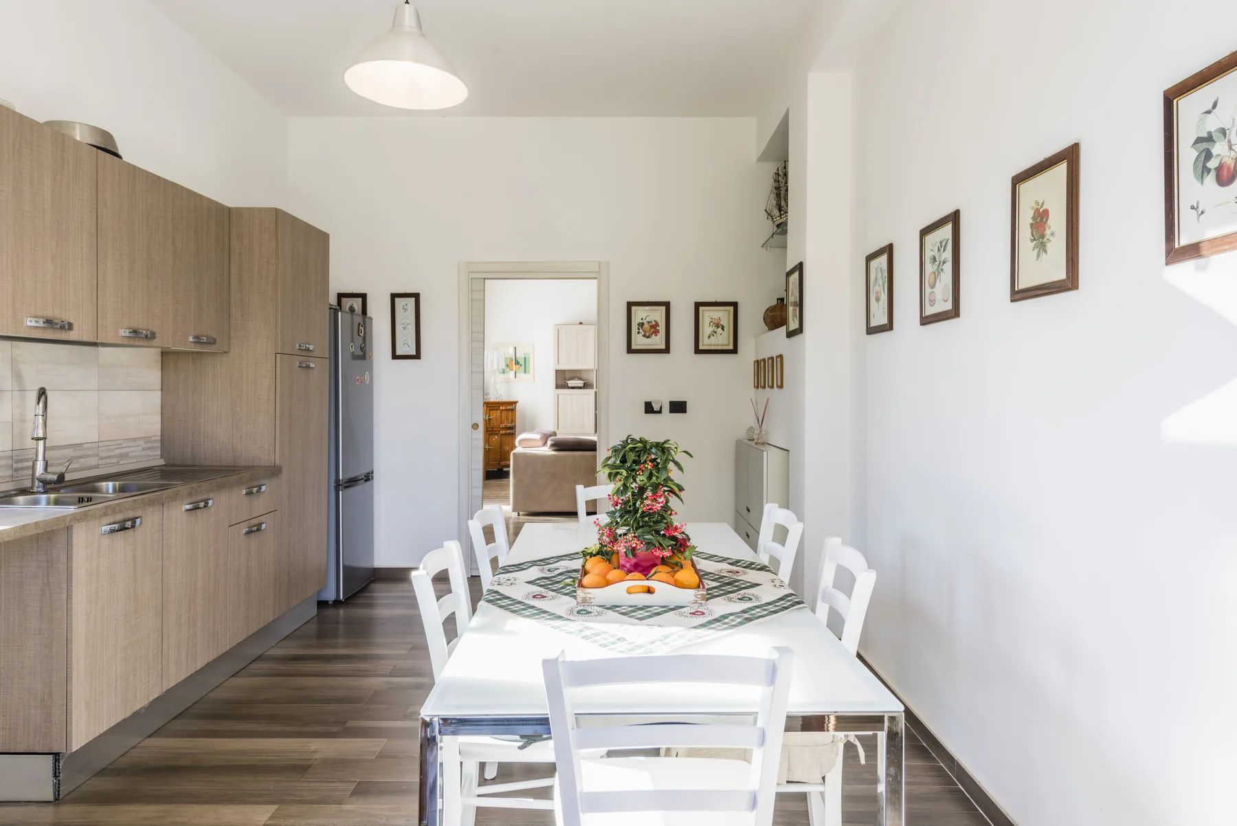 Un comedor con la mesa puesta junto a una cocina.