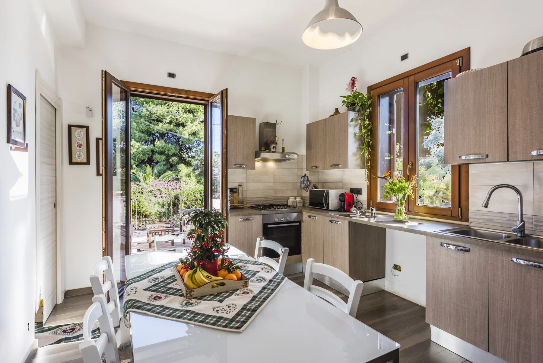 Una cocina luminosa con zona de comedor, muebles de madera y una mesa.