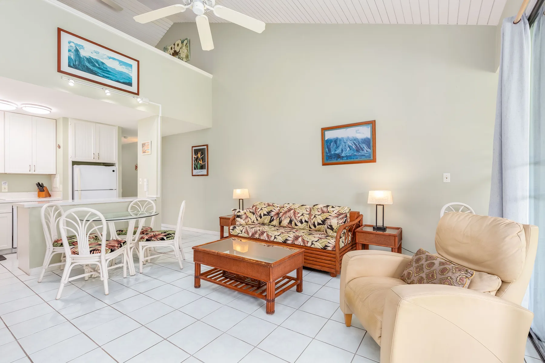 A living room with seating, a coffee table, and an adjoining kitchen.