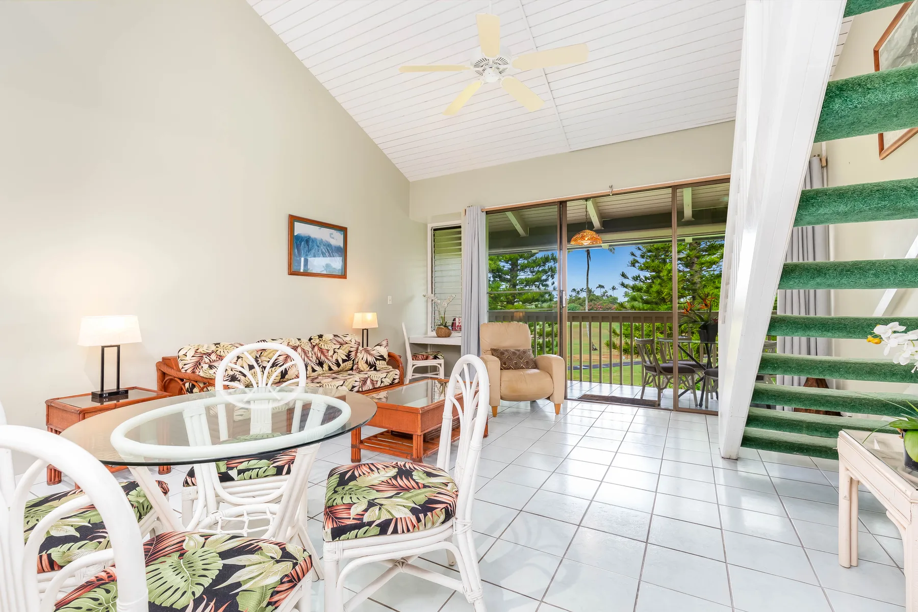 A bright living and dining area opens onto a balcony through sliding glass doors.