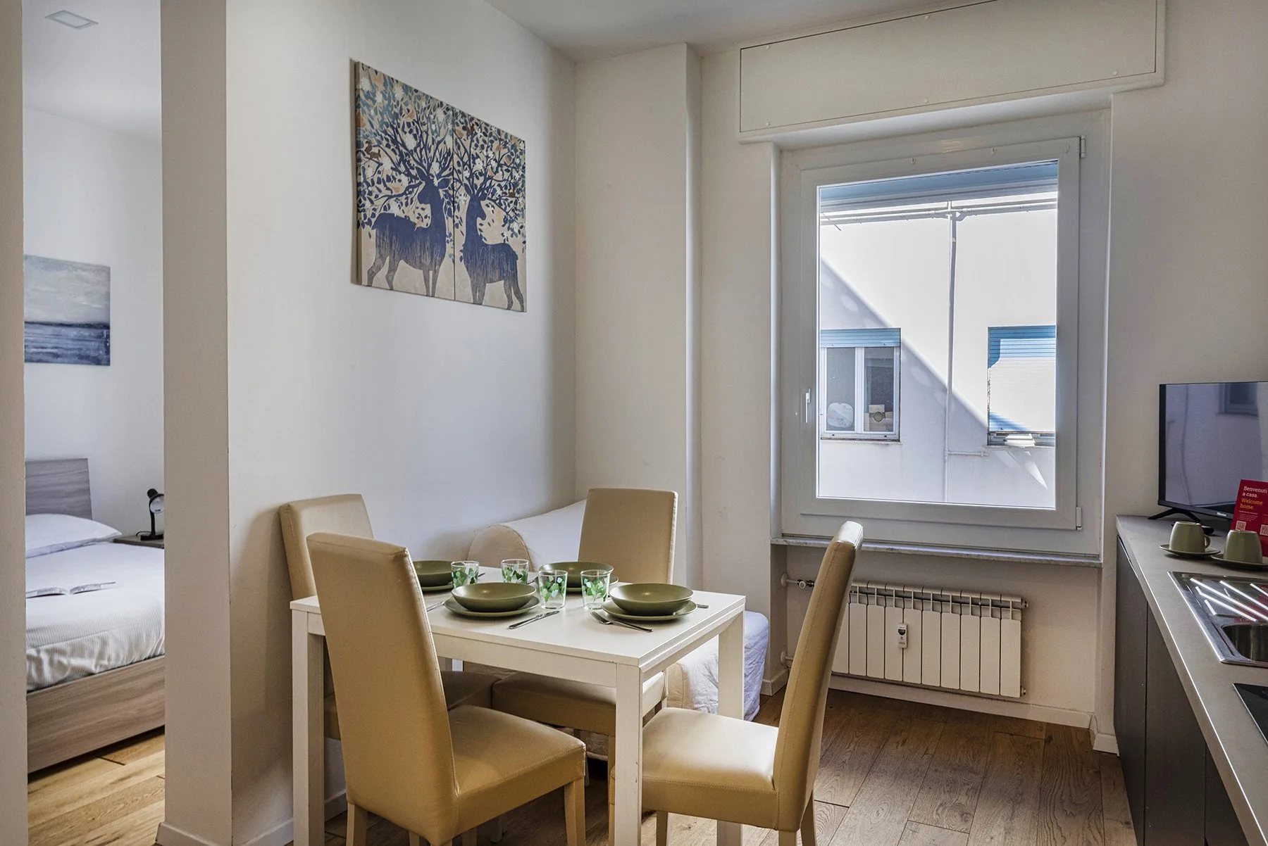 A dining area with a table and chairs beside a large window.