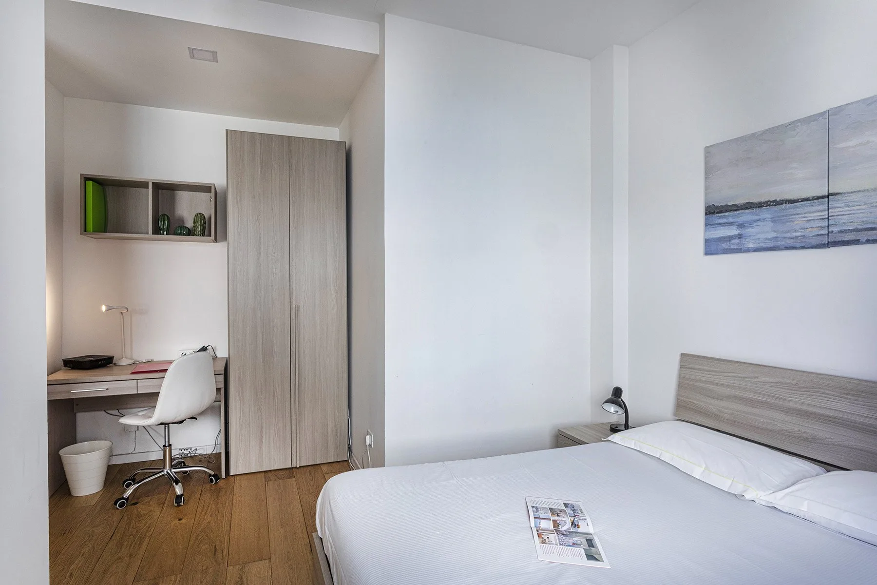 A bedroom with a bed, desk, and chair.