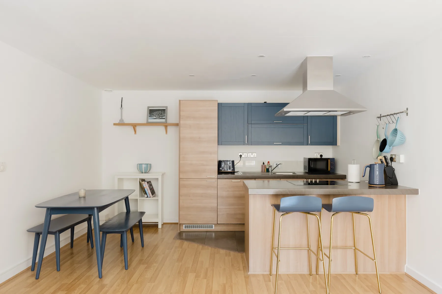 Una cocina luminosa con una isla de frente de madera y una mesa de comedor.