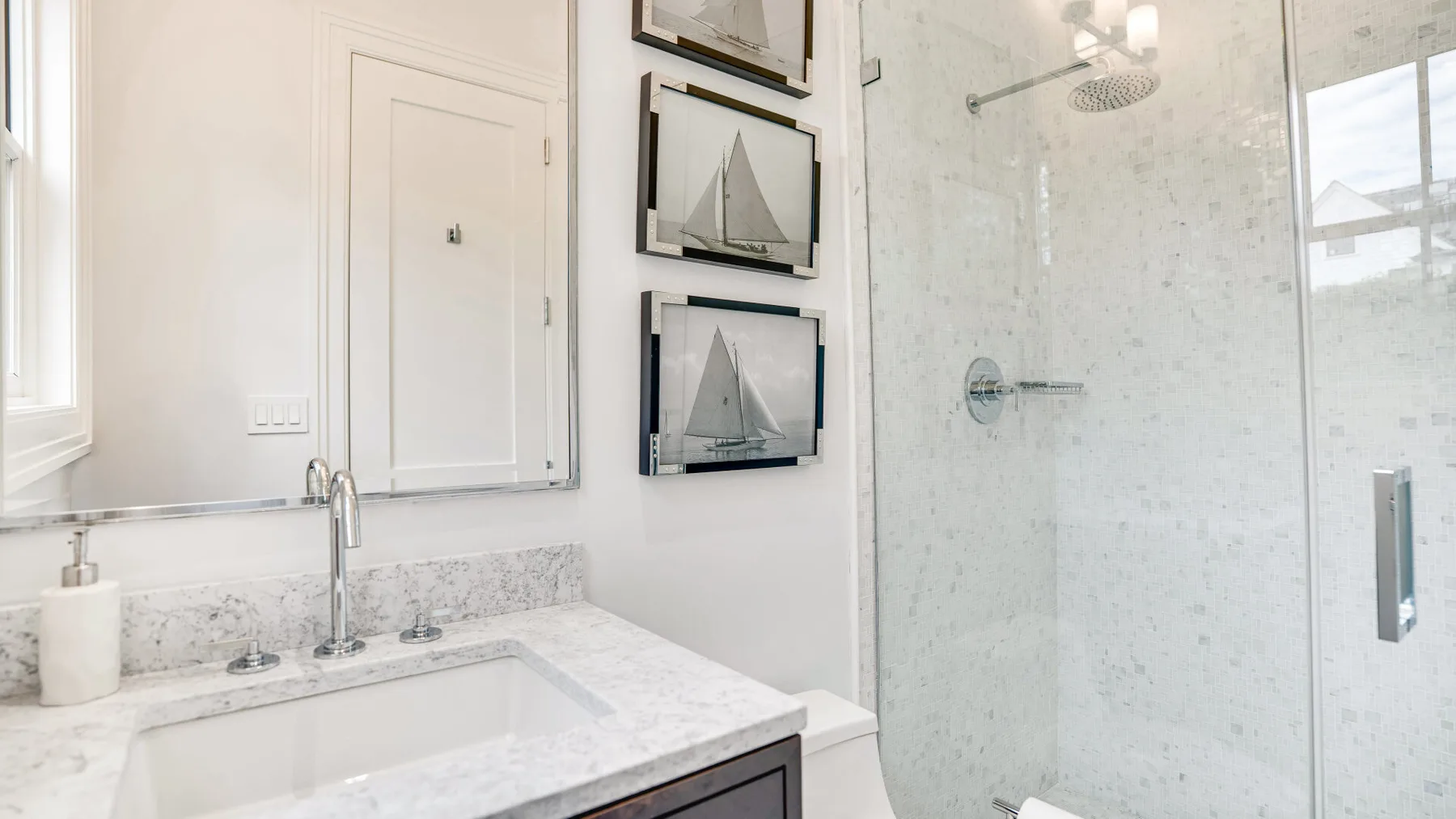 Un baño luminoso con lavabo y ducha con mampara de vidrio.