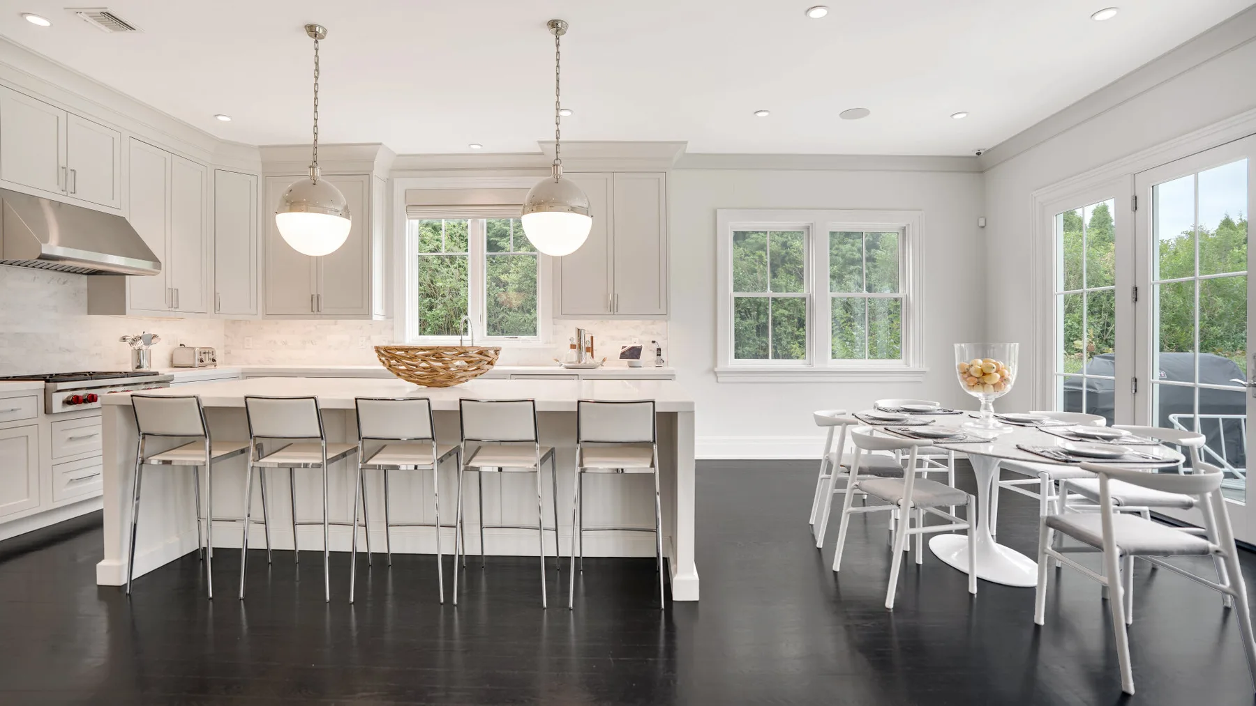 Una cocina y comedor luminosos con una barra larga y una mesa de comedor.