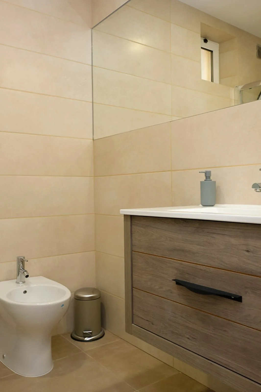 Un baño alicatado con mueble de lavabo y bidé.