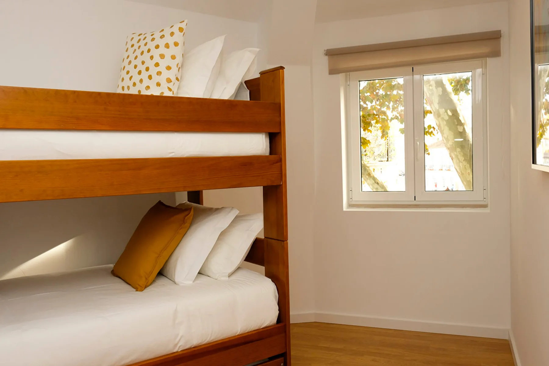 Un dormitorio con una litera de madera y una ventana.