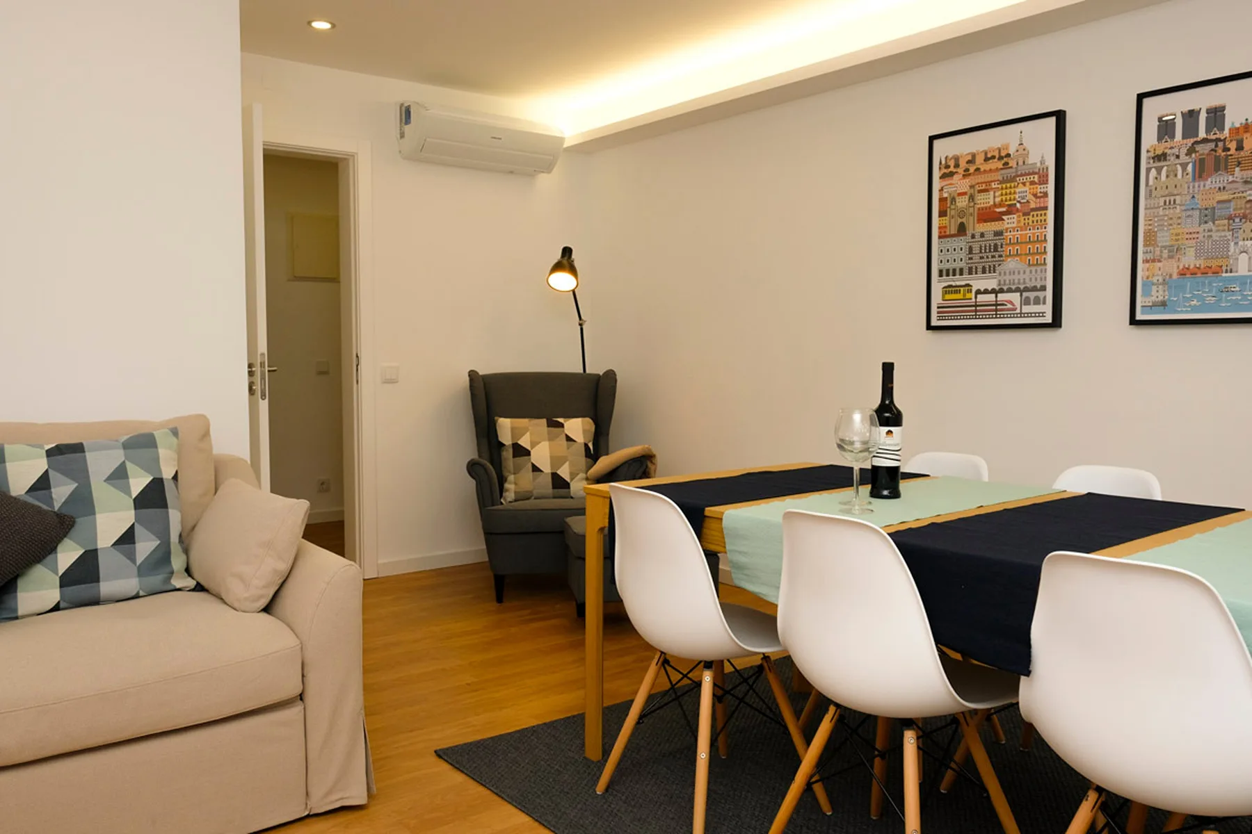 Sala de estar y comedor con una mesa, asientos y cuadros en la pared.