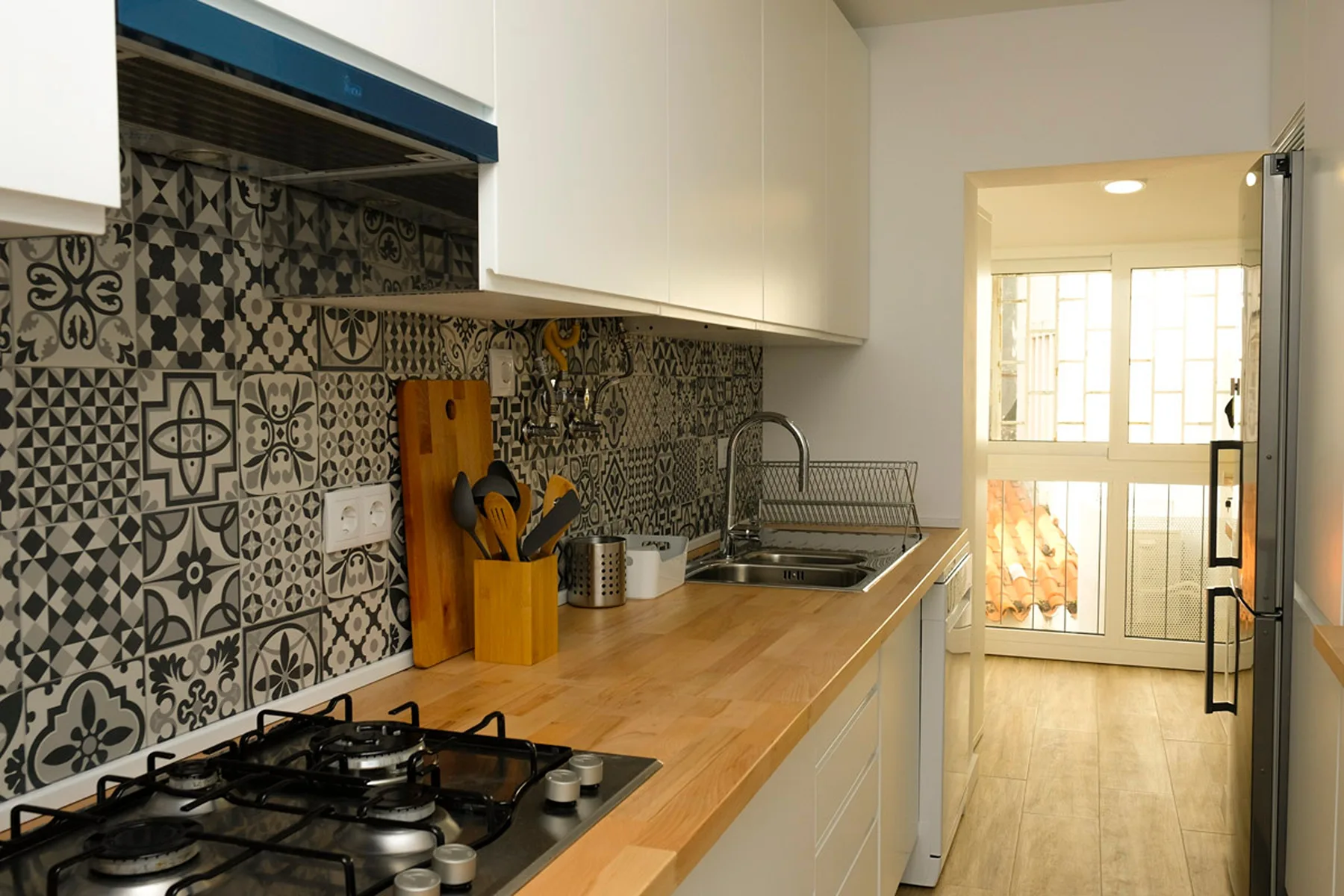 Una cocina con un salpicadero estampado, una encimera y una placa de gas.