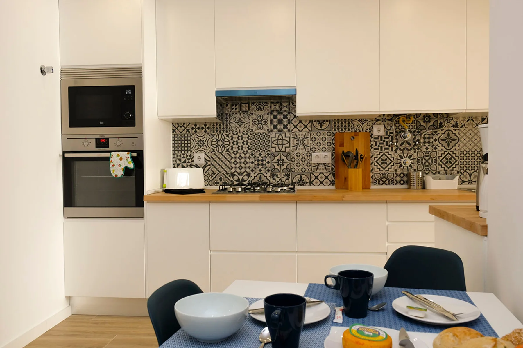 Una cocina moderna con salpicadero estampado y una mesa de comedor en primer plano.