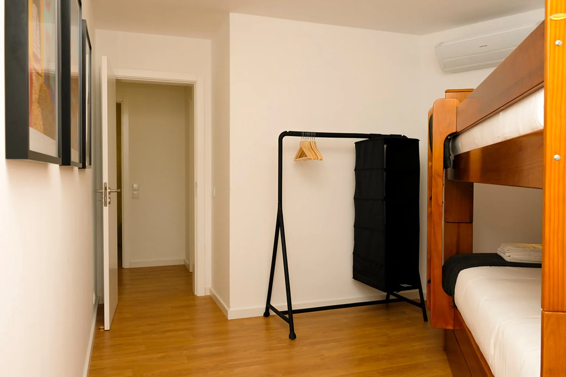 Dormitorio con literas, un perchero y una puerta.