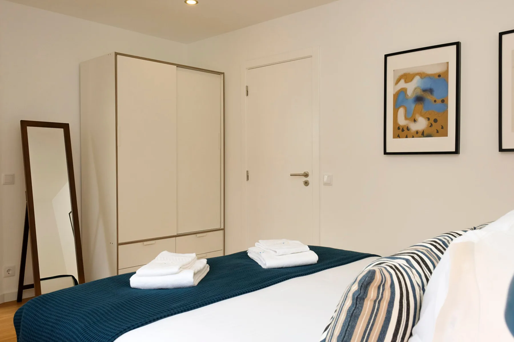 Un dormitorio con una cama bien hecha y toallas dobladas.