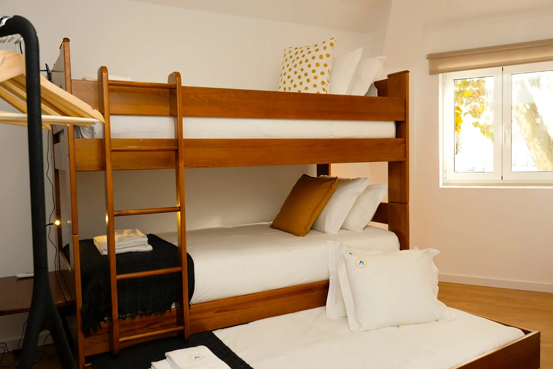 Un dormitorio con una litera de madera y una ventana.