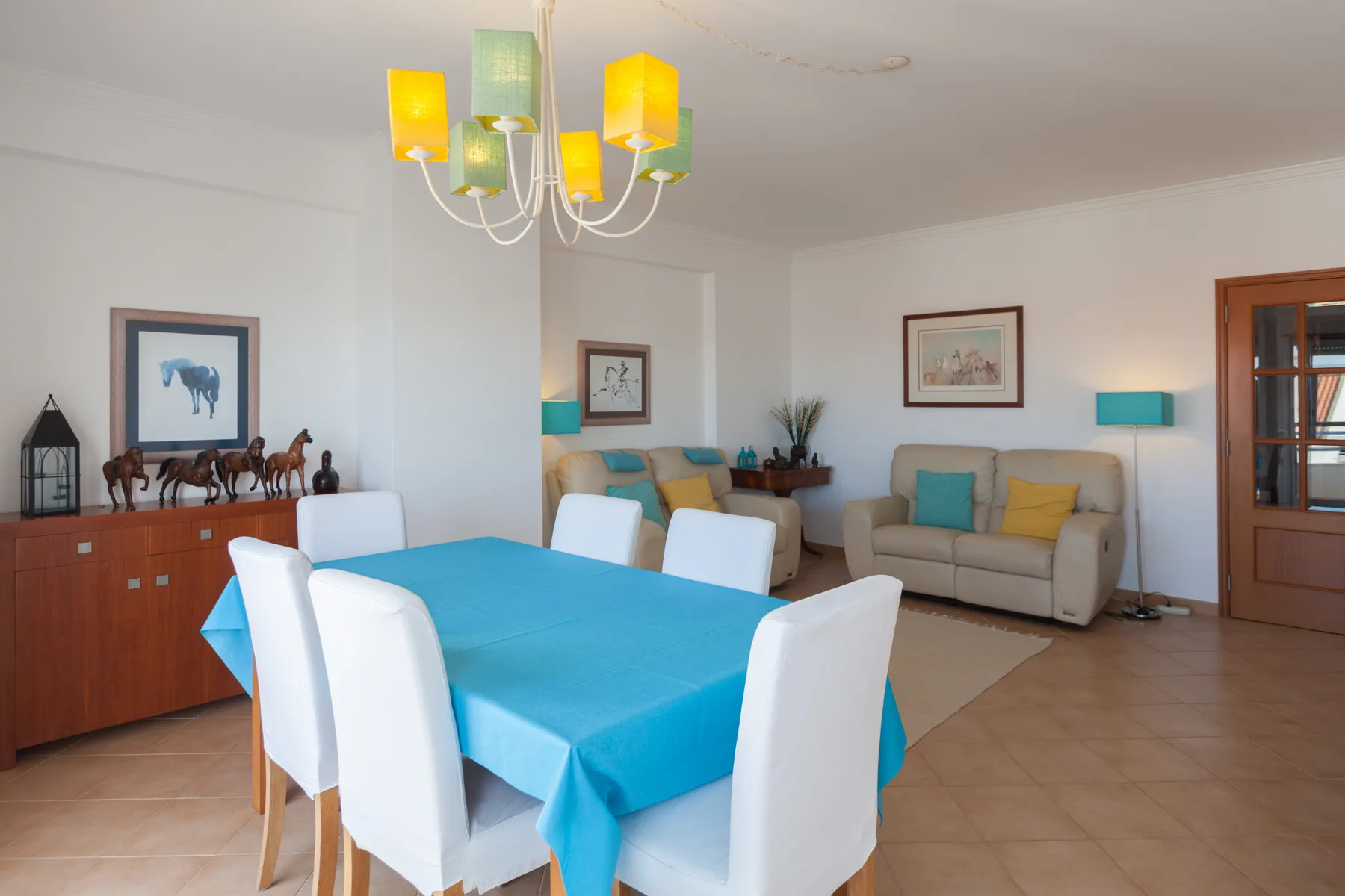 Comedor y sala de estar con una mesa cubierta de azul y asientos.