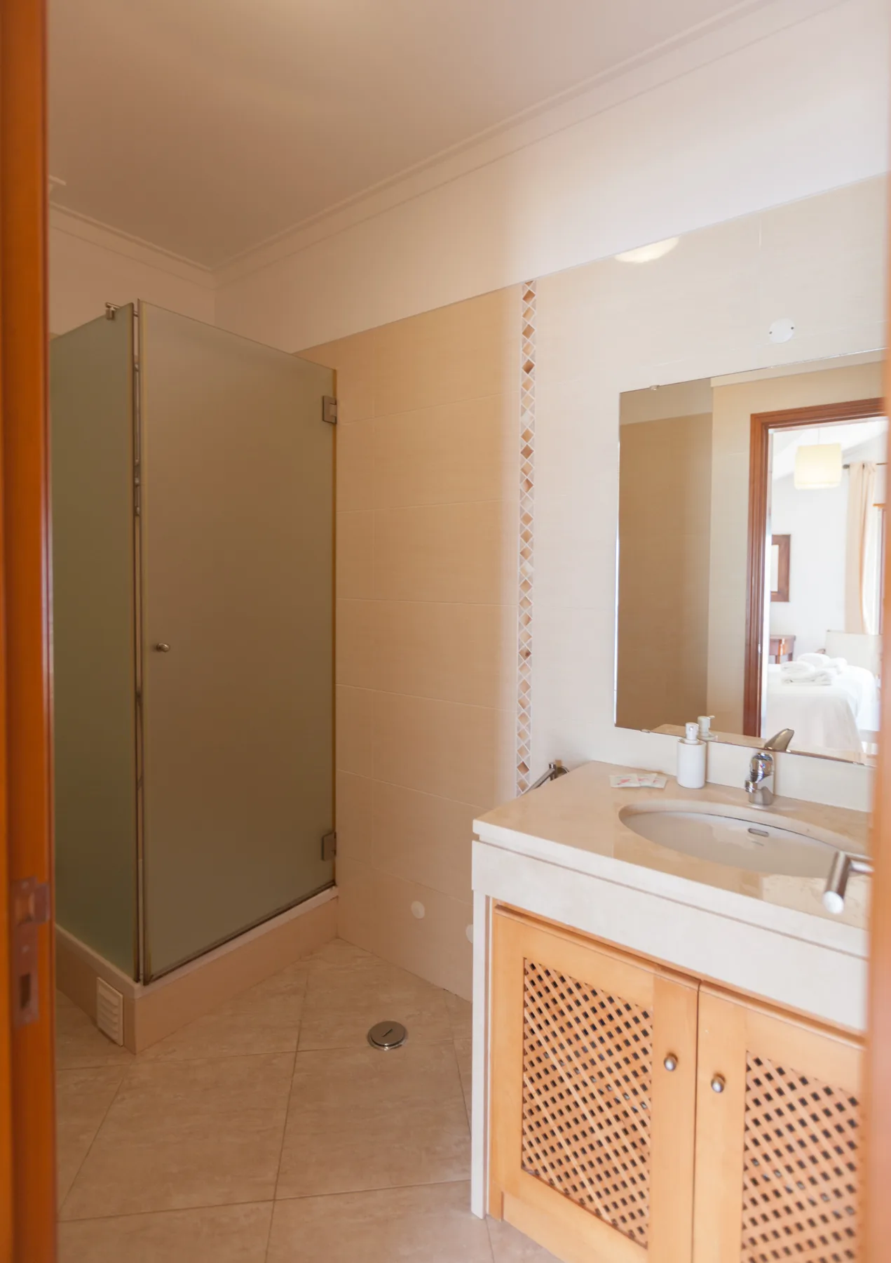 A bathroom with a sink vanity and a shower.