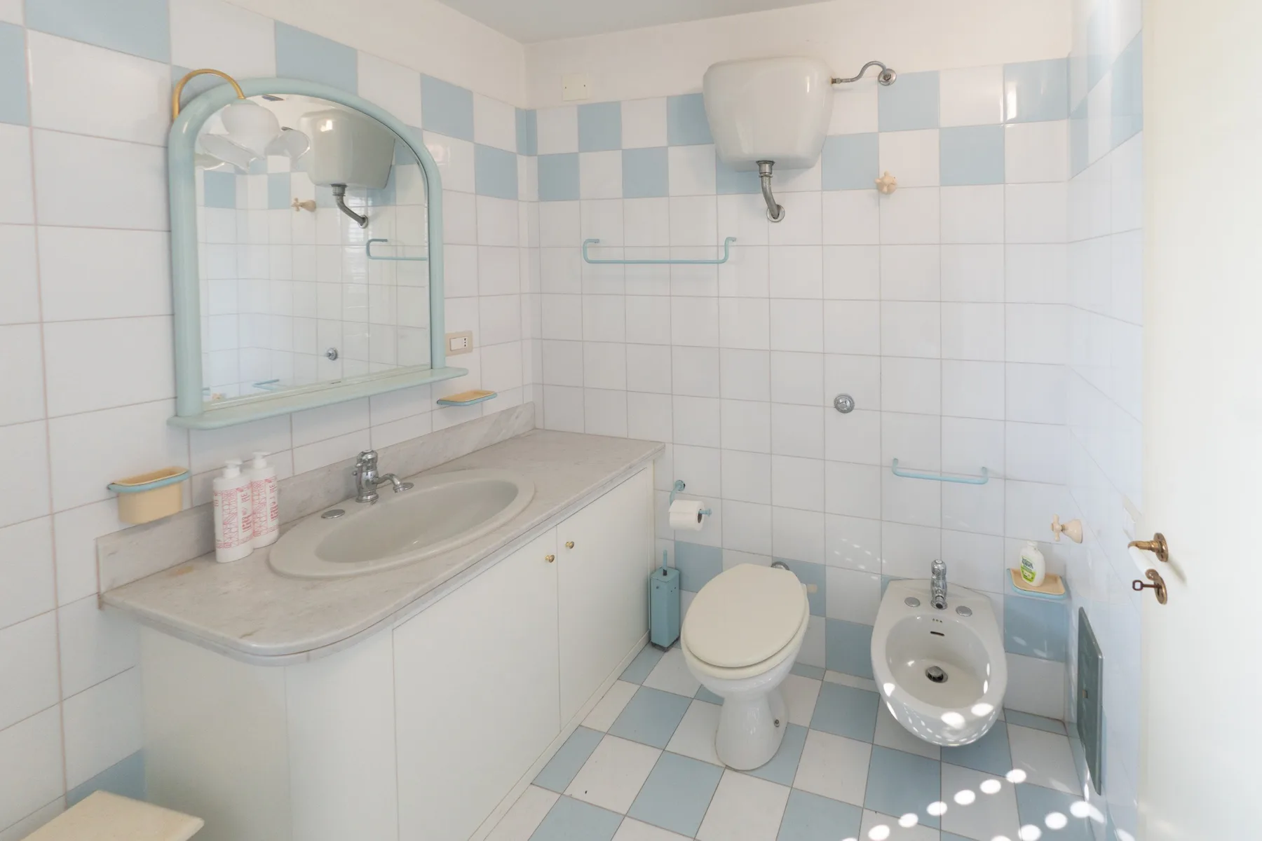 Un baño con azulejos, lavabo, inodoro y bidé.