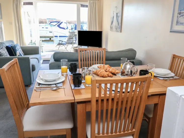 A dining area with a set table and seating beside a living room.