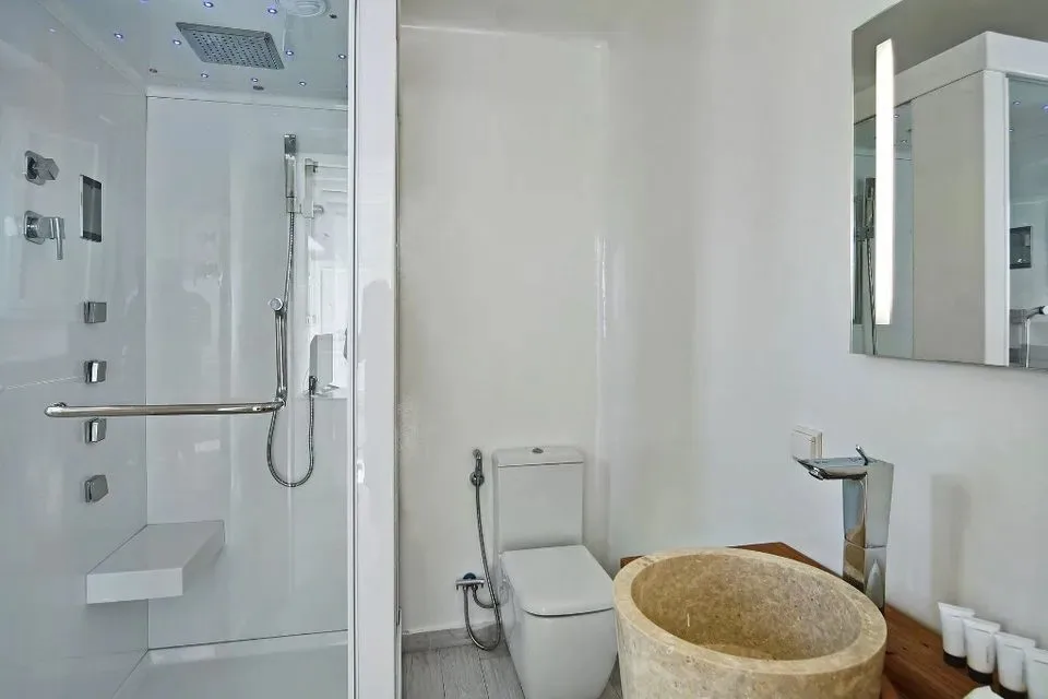 Un baño con ducha de vidrio, inodoro y bañera independiente.