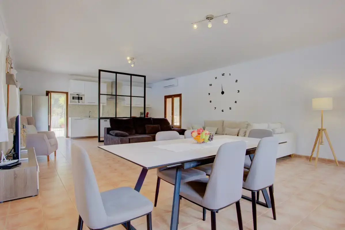 A bright open-plan living and dining area with a large table and seating.