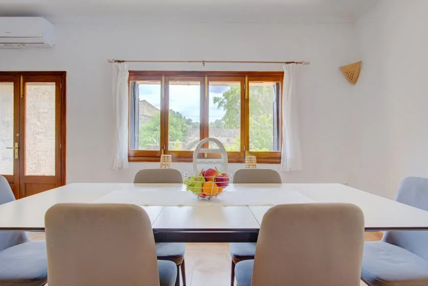 A bright dining area with a long table and a large window.