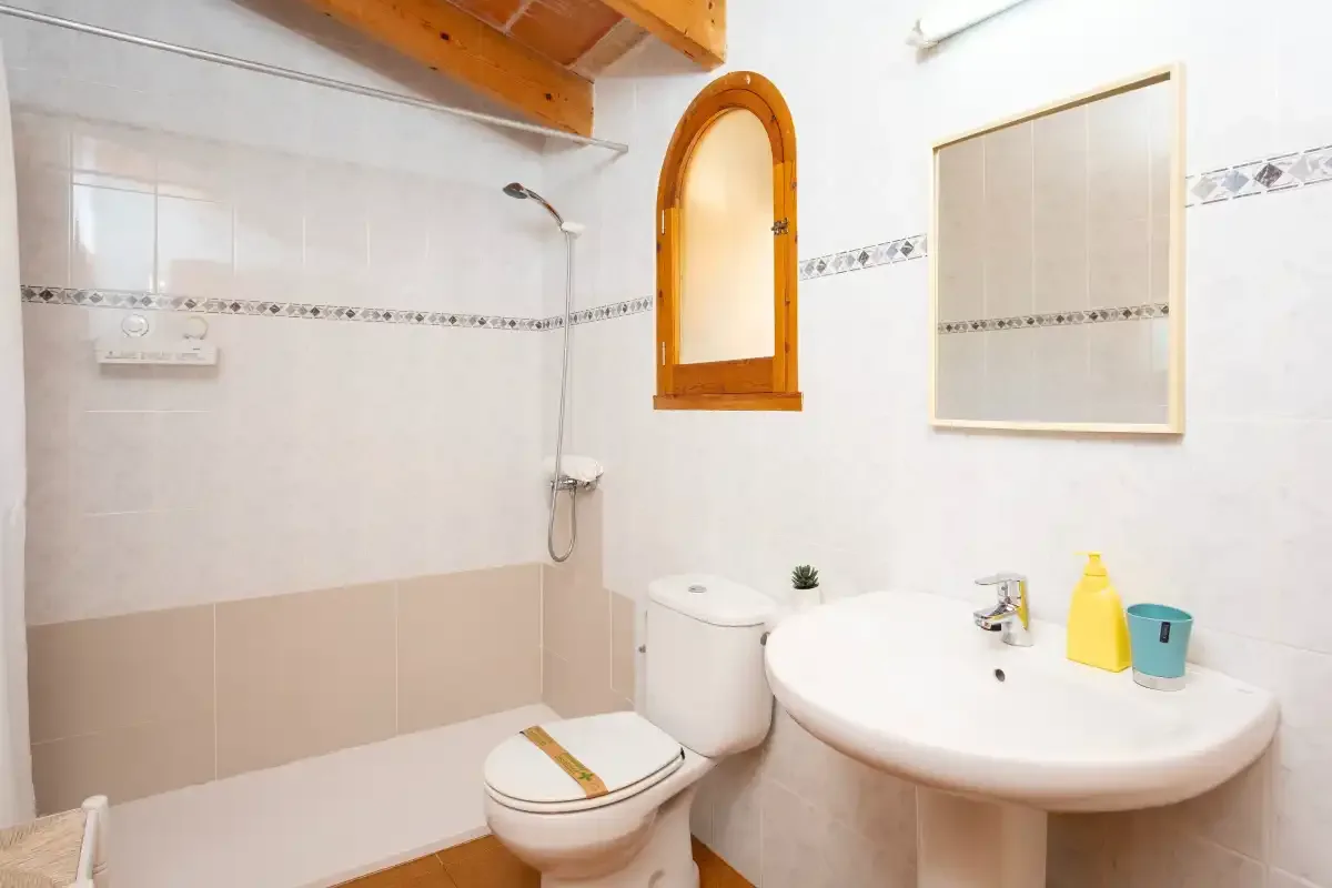A tiled bathroom with a shower, toilet, and sink.