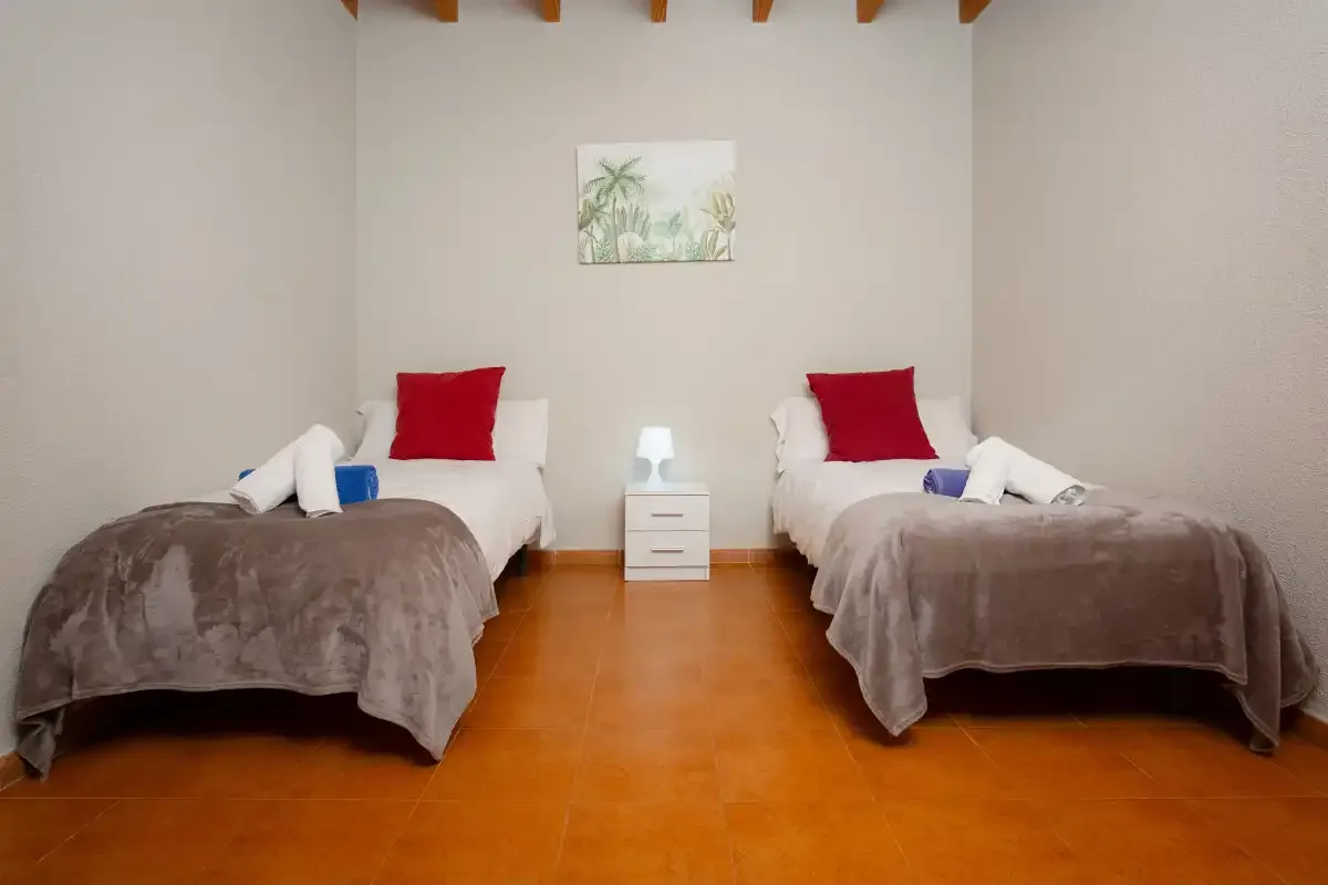 A twin bedroom with two single beds and a small bedside table.
