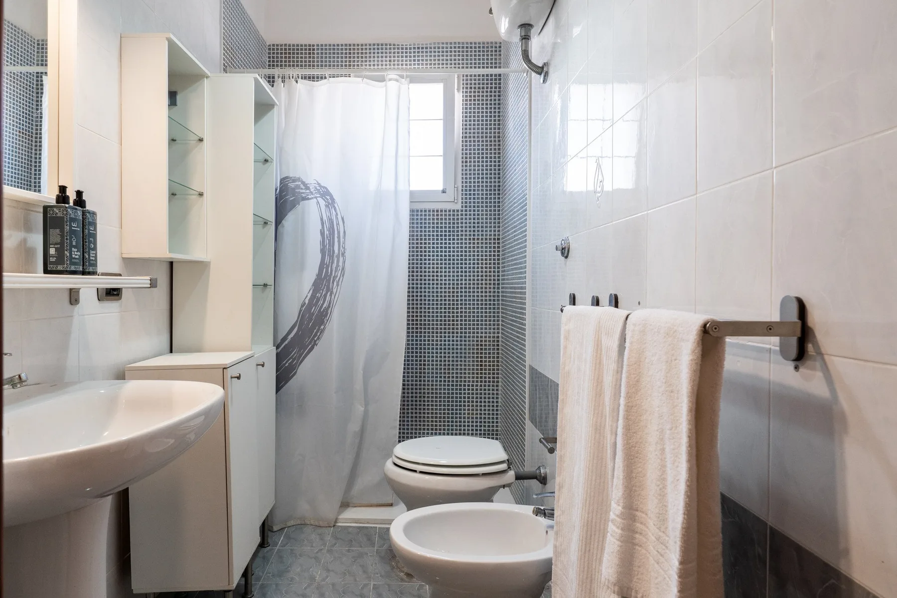 Un baño con lavabo, inodoro y cortina de ducha.
