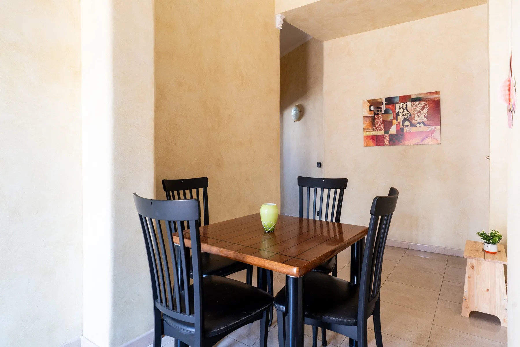 Un comedor con una mesa de madera y sillas oscuras.