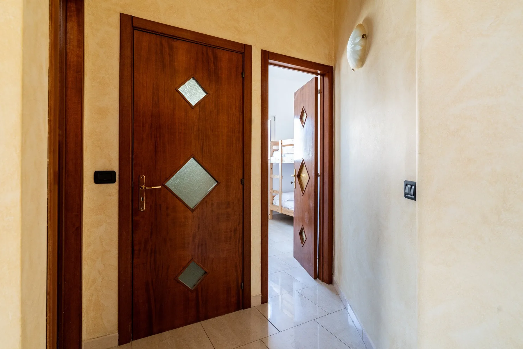 Un pasillo con una puerta de madera y una entrada abierta.