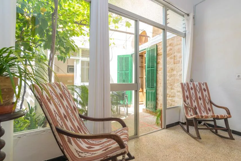 A bright sitting area with patterned seating beside large glass doors.