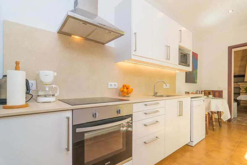 A bright kitchen with white cabinets, a countertop, and a built-in oven.