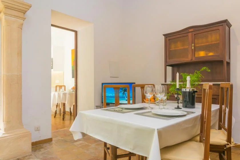 A dining area with a set table and a wooden hutch against the wall.