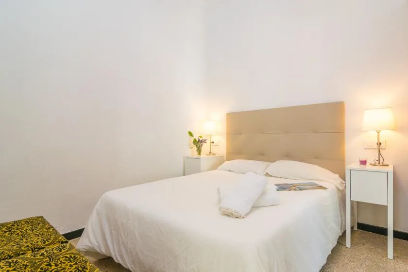 A bedroom with a neatly made bed and matching bedside tables.